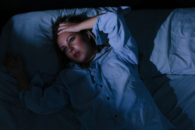 vrouw ligt wakker op bed