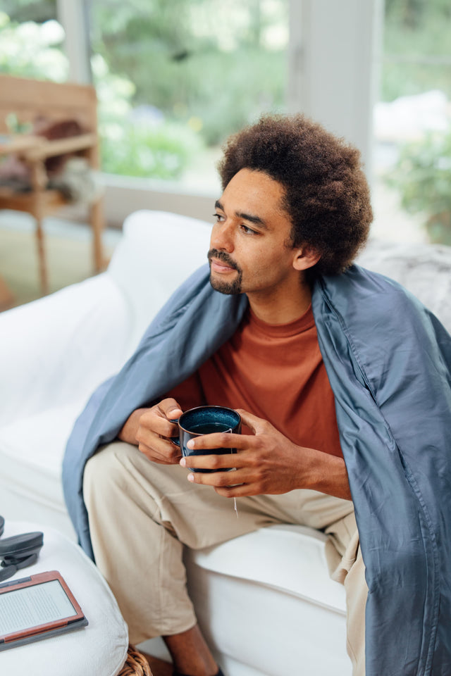 Novaline weighted blanket with bamboo cover blue man thinking with cup of tea on the couch